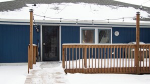 A blue building with a wooden deck and a covered outdoor area. - Spacious 4BR Fennville Farmhouse w/ Pool Table (Fennville)