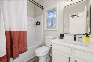 Un baño con bañera, inodoro y lavamanos.