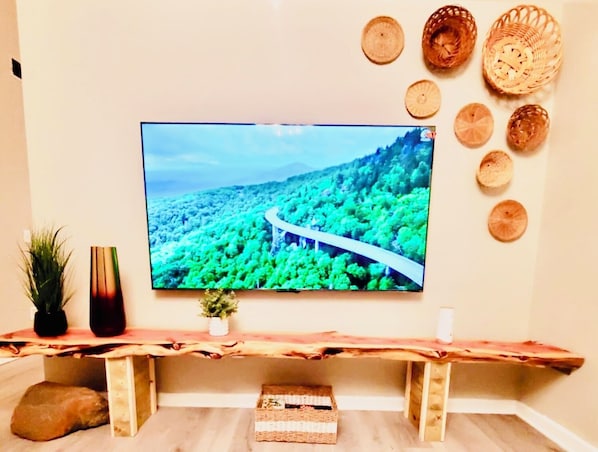 A television mounted on a wall displaying a scenic landscape.