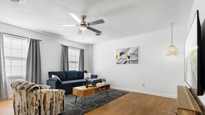 Una sala de estar moderna con un sofá, una mesa de centro y un ventilador de techo.