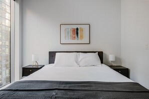 Relax in a stylish space with a large bed, bedside tables, and a framed artwork.