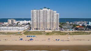 Een hotel aan het strand met meerdere verdiepingen, een zandstrand ervoor en uitzicht op de oceaan.