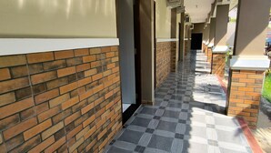 Un pasillo con paredes de ladrillo, suelo de baldosas y unidades de aire acondicionado.