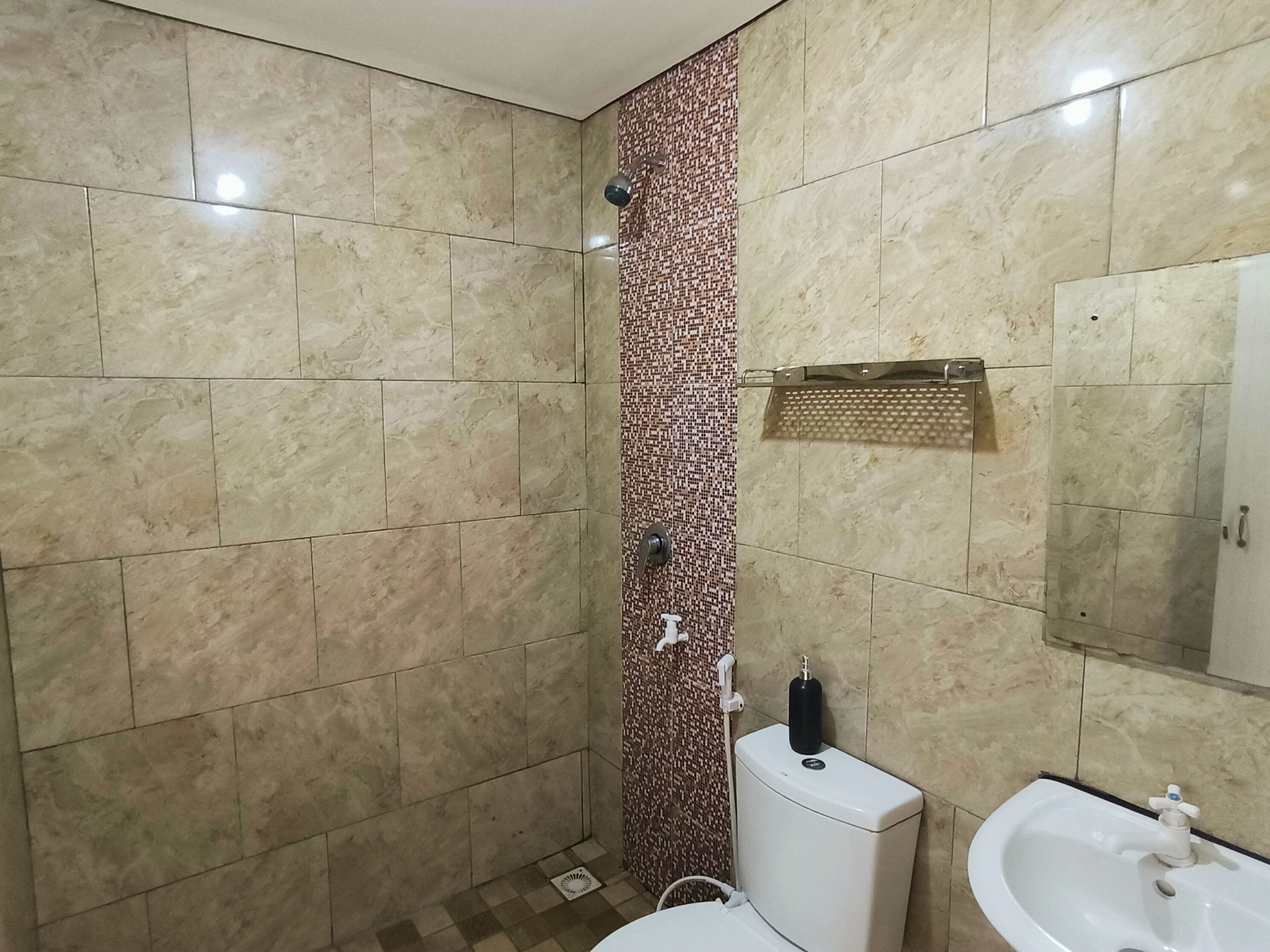 A bathroom with a shower, toilet, and sink.