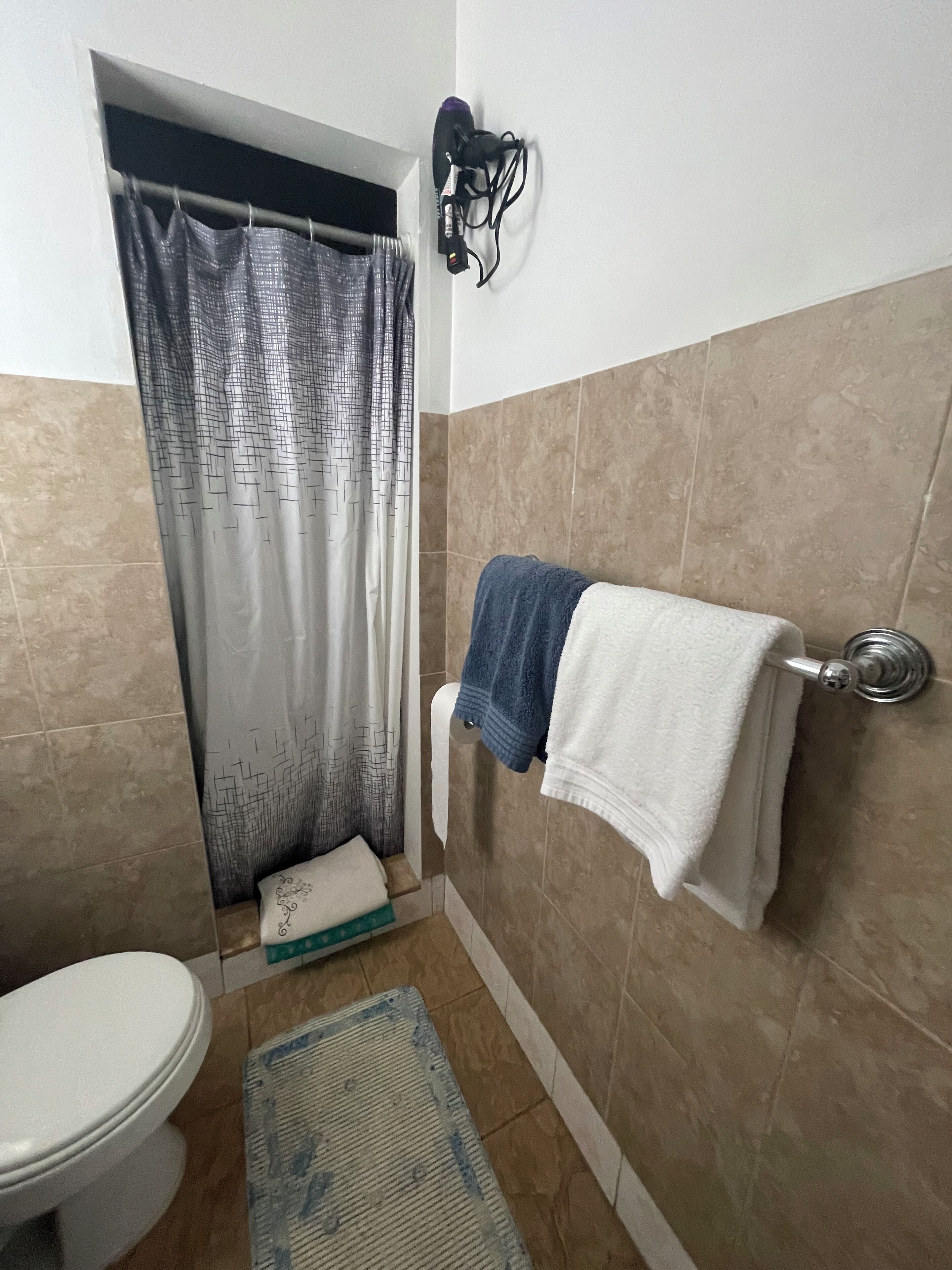 Een haardroger, handdoeken, zeep, toiletpapier