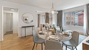 Un comedor moderno con una mesa redonda, sillas grises y una lámpara colgante.
