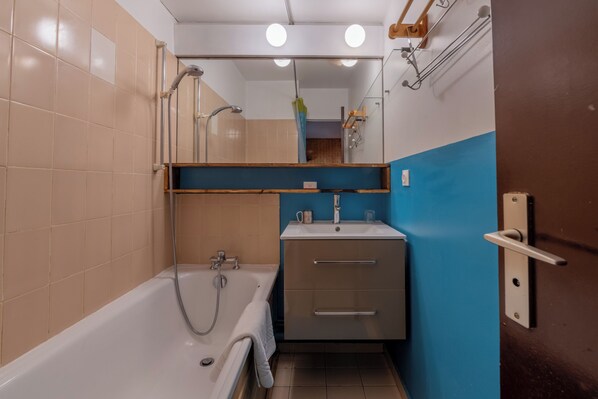 Un baño con bañera, lavabo y espejo.