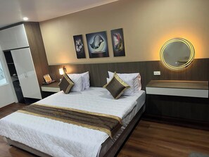 Ein Hotelzimmer mit einem großen Bett, einem Nachttisch, einem Spiegel und Bildern an der Wand.