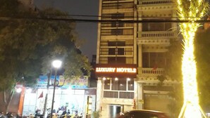 Un edificio alto con un letrero que dice 'Luxury Hotels' en la parte superior.