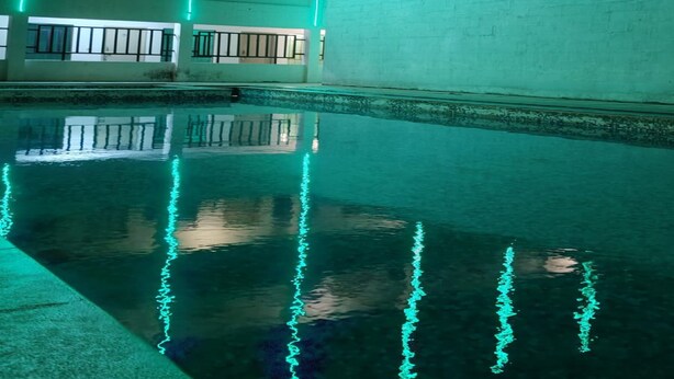 A building with a reflective pool and vertical light strips. - Hotel Tenach (Puducherry)