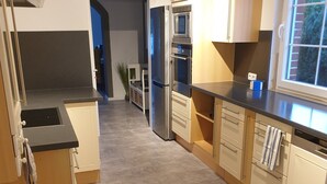 Una cocina moderna con horno empotrado, microondas y refrigerador.