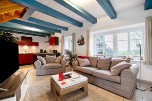 Een woonkamer met twee banken, een salontafel en een televisie.