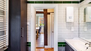 Une salle de bain moderne avec un grand lavabo blanc, un miroir et un porte-serviettes.