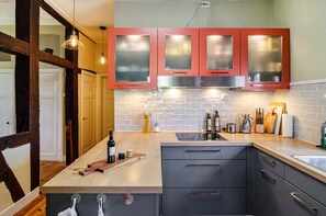 A kitchen with wooden cabinets, a tiled backsplash, and a wooden countertop.