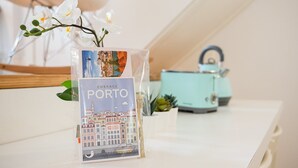 A travel brochure titled "Embrace Porto" on a white table with a teal-colored kettle in the background.