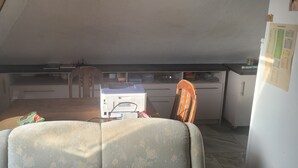 Cuina compacta amb taula de dinar, cadire i nevera.
