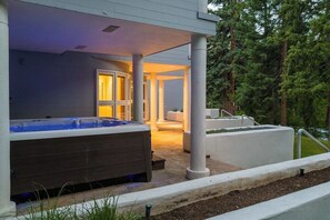 A hot tub outside a building with a covered patio area. - 6 Bedroom Riverside Haven in East Vail (Vail)