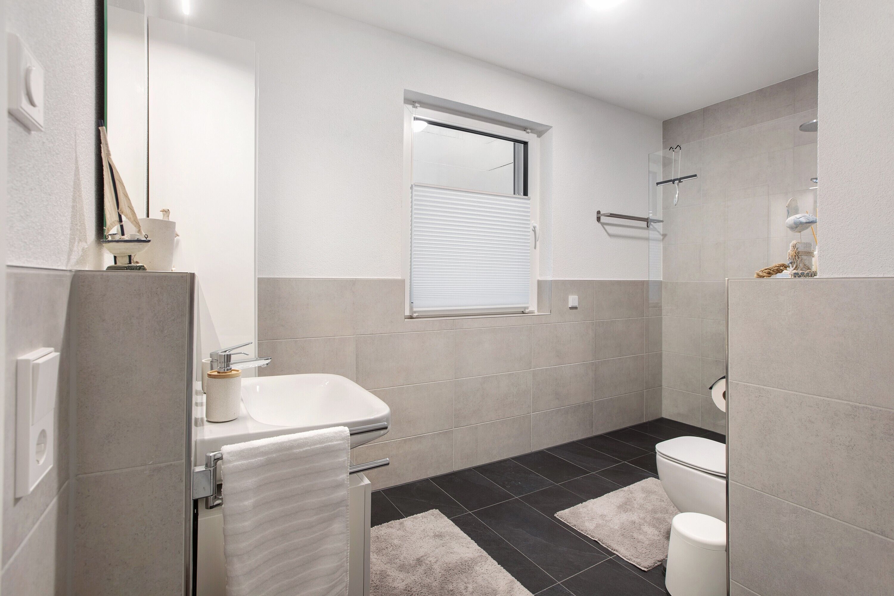 A modern bathroom with a bathtub, toilet, and shower.