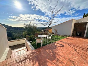 A patio with a table and chairs, a brick pathway, and a view of a mountainous landscape. - Air-conditioned mazet for 7 people on the Domaine de Valcros in La Londe-les-Maures (LA LONDE LES MAURES)