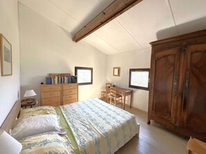 A bedroom with a bed, a wooden wardrobe, a desk with chairs, and a window. - Air-conditioned mazet for 7 people on the Domaine de Valcros in La Londe-les-Maures (LA LONDE LES MAURES)