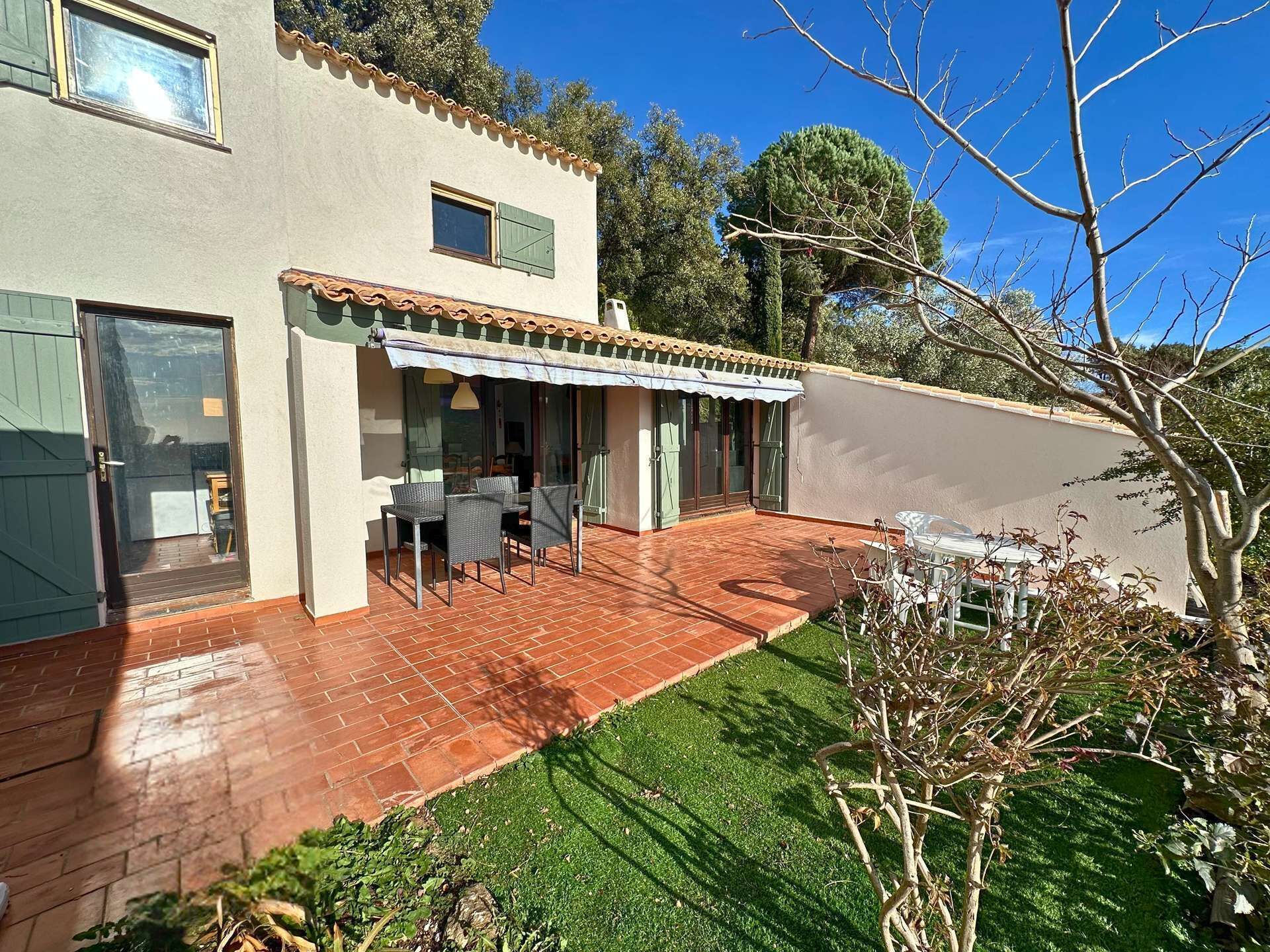 A house with a patio, a covered outdoor seating area, and a small garden.