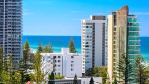 A coastal cityscape with modern high-rise buildings, including a prominent Carlton hotel, and a clear view of the ocean.