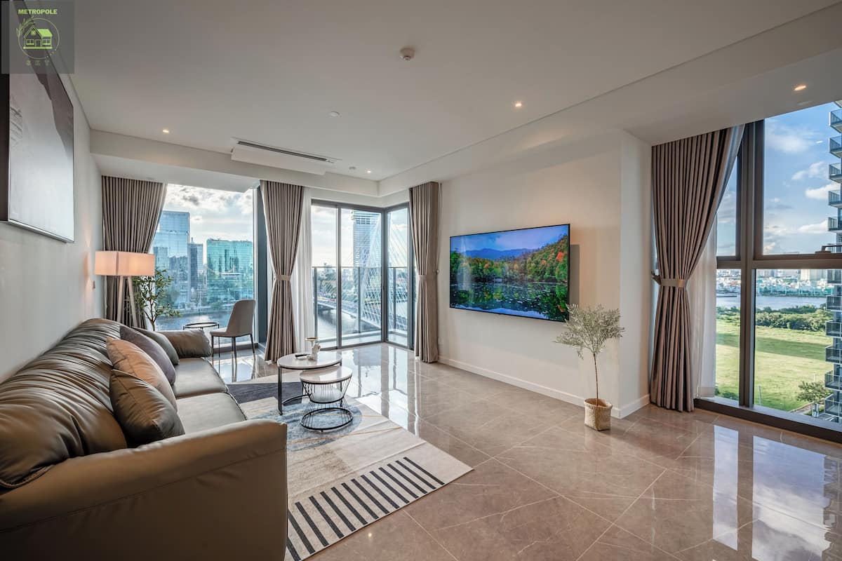 A modern living room with a sofa, a TV, and a city view.