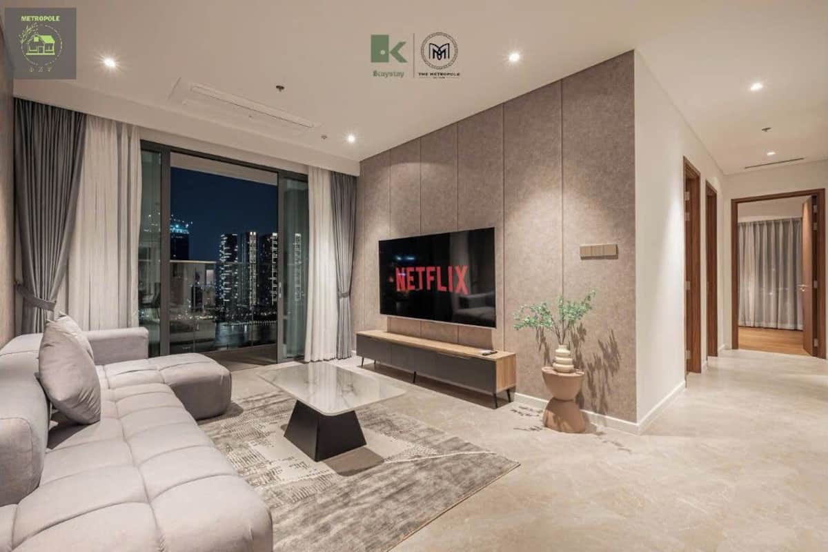 A modern living room with a large flat-screen TV, a sofa, and a coffee table.