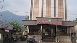 Egy épület, melynek bejáratánál egy „ASOKA INN” feliratú tábla található, modern építészeti stílusban, feltűnő bejárattal és a bejárathoz vezető lépcsőkkel.