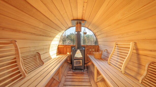 A sauna with wooden benches and a central heating unit. - Sokcho Biroso Private Cottage (Sokcho)