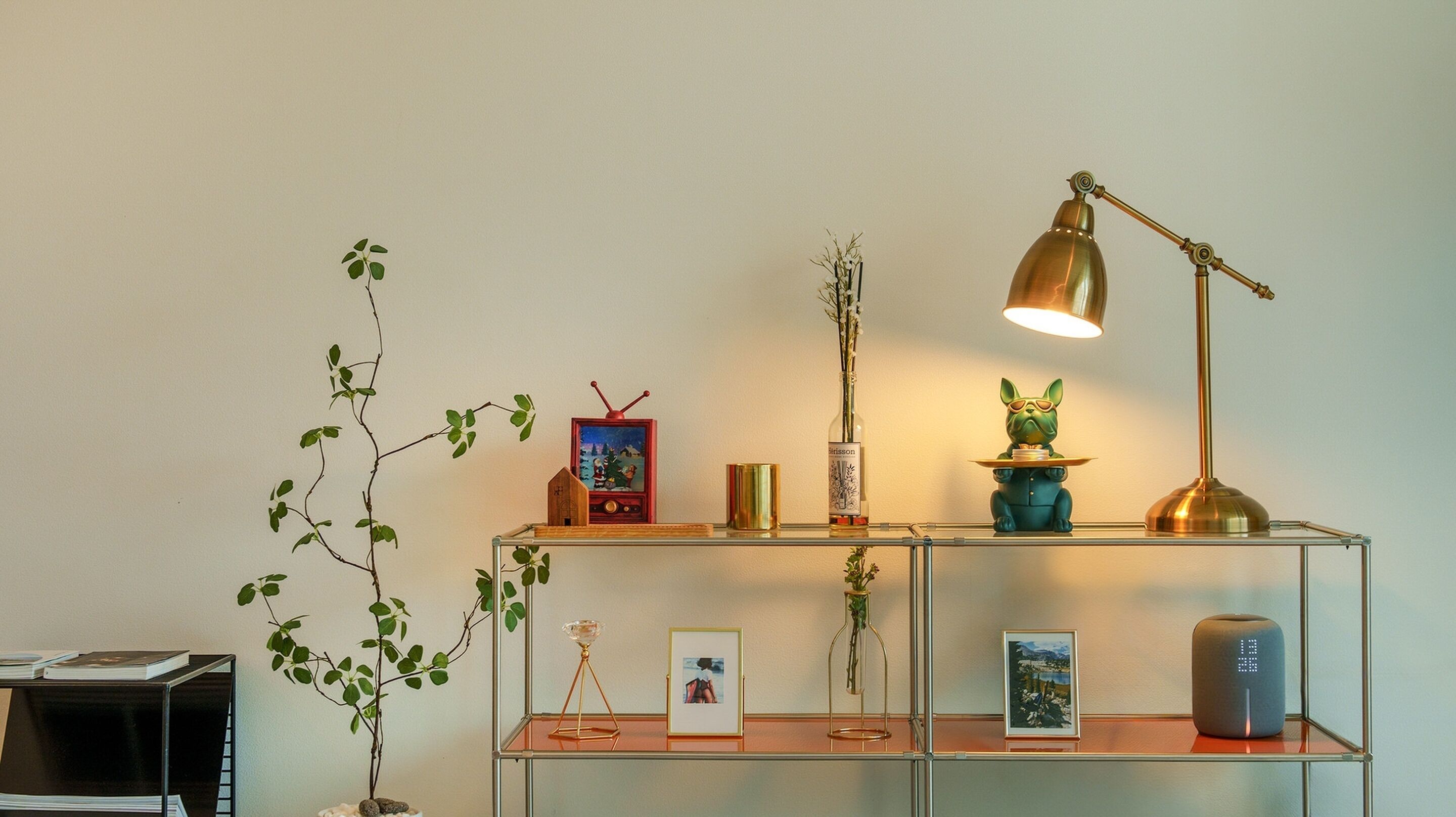 A shelf with various decorative items including a framed picture, a bottle, a small figurine, and a lamp.