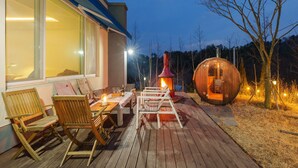 A wooden deck with outdoor seating and a wood-burning stove. - Sokcho Biroso Private Cottage (Sokcho)