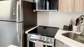 Eine moderne Küche mit Edelstahlgeräten, darunter ein Kühlschrank, ein Backofen und eine Mikrowelle.