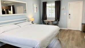 Ein Hotelzimmer mit einem großen Bett, einem Schreibtisch und einem Stuhl.