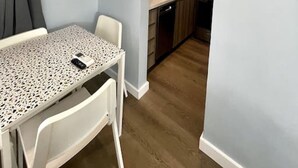 Une cuisine compacte au design moderne, dotée d’un four encastré et d’un évier.