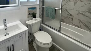 Une salle de bain moderne équipée de toilettes, d’un lavabo et d’une douche.