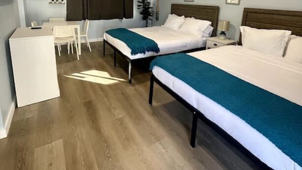 Une chambre d’hôtel avec deux lits, un bureau et une chaise.