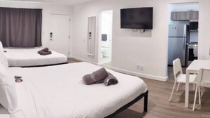 A hotel room with two beds, a TV, a kitchenette, and a dining area. - Charming DBL w/pool& parking 15 min to FLL & Beach (Hollywood)
