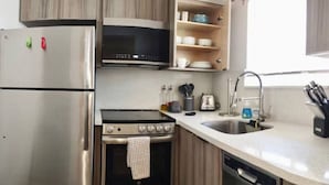 A modern kitchen with stainless steel appliances, including a refrigerator, microwave, stove, and dishwasher. - Charming DBL w/pool& parking 15 min to FLL & Beach (Hollywood)