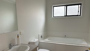 Un bany amb un lavabo, vàter i banyera.