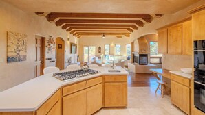 A spacious kitchen with wooden cabinets, a large island, and a view to the living area. - Amazing views, Stunning Sunny Interior (Santa Fe)