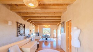 A spacious hallway with wooden beams, a bench, a table, and a mannequin. - Amazing views, Stunning Sunny Interior (Santa Fe)