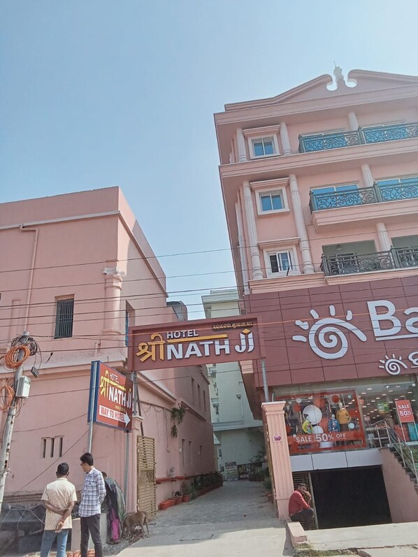 A pink building with a sign for Hotel Nath Ji.