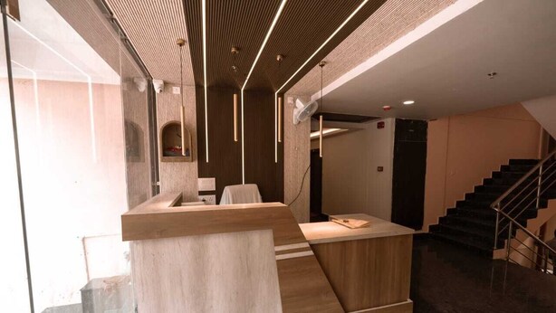 Een moderne receptie met een houten balie, een trap en een glazen wand.