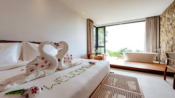 Habitación de hotel con cama, bañera, una silla y vistas a zonas verdes.
