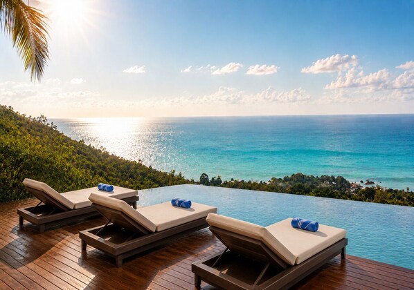 A poolside area with lounge chairs and a view of the ocean. - Anzhu Seamate Villa Samui (Koh Samui)