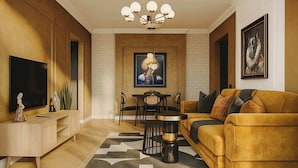 Una sala de estar moderna con sofá, televisión, comedor y obras de arte.