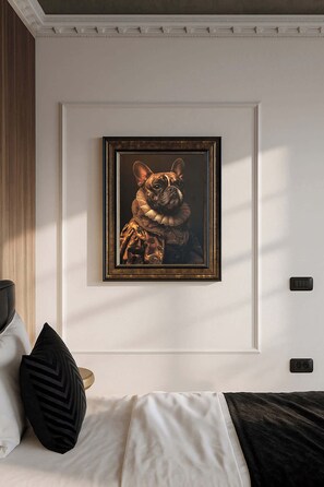 A bedroom with a bed, pillows, a framed artwork of a dog, and a wall-mounted light switch.