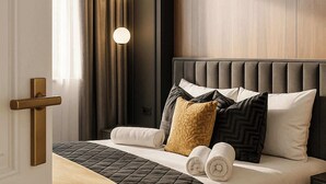 Une chambre moderne avec un grand lit, une tête de lit en bois et une table de chevet.