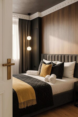 A modern bedroom with a large bed, a wooden headboard, and a bedside table.